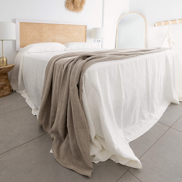 Rustic heavy linen waffle throw crafted from a cozy waffle weave, blanket adds a layer of warmth and style to any bedroom decor.