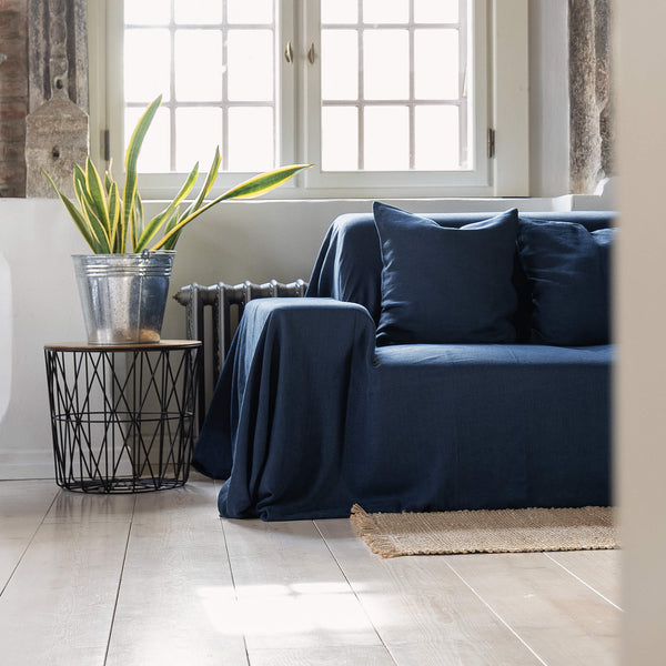 Navy blue linen couch cover designed and crafted to elevate your interior with a fresh look and great energy. It offers a practical solution for safeguarding your furniture against the playful antics of your beloved pets.