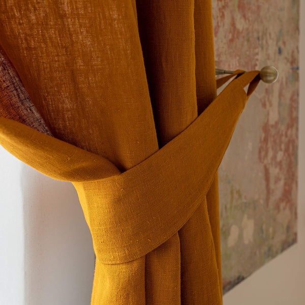 Our amber yellow linen curtain tie-back is the perfect solution for keeping your curtains looking neat and stylish. Made from the highest-quality European linen, they offer durability and a luxurious feel.