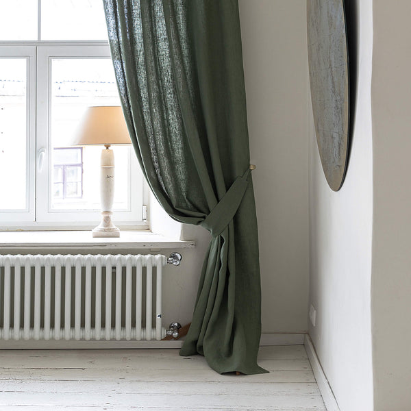 Our moss green linen curtain tie-back is the perfect solution for keeping your curtains looking neat and stylish. Made from the highest-quality European linen, they offer durability and a luxurious feel.