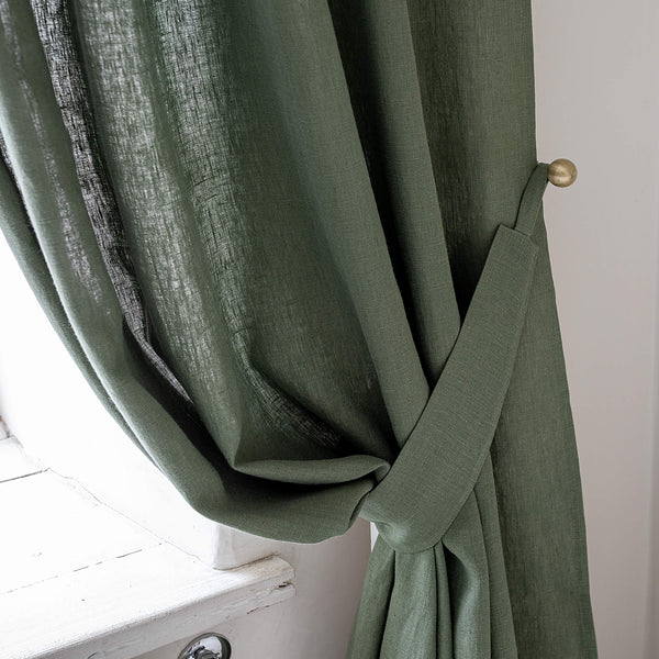 Our moss green linen curtain tie-back is the perfect solution for keeping your curtains looking neat and stylish. Made from the highest-quality European linen, they offer durability and a luxurious feel.