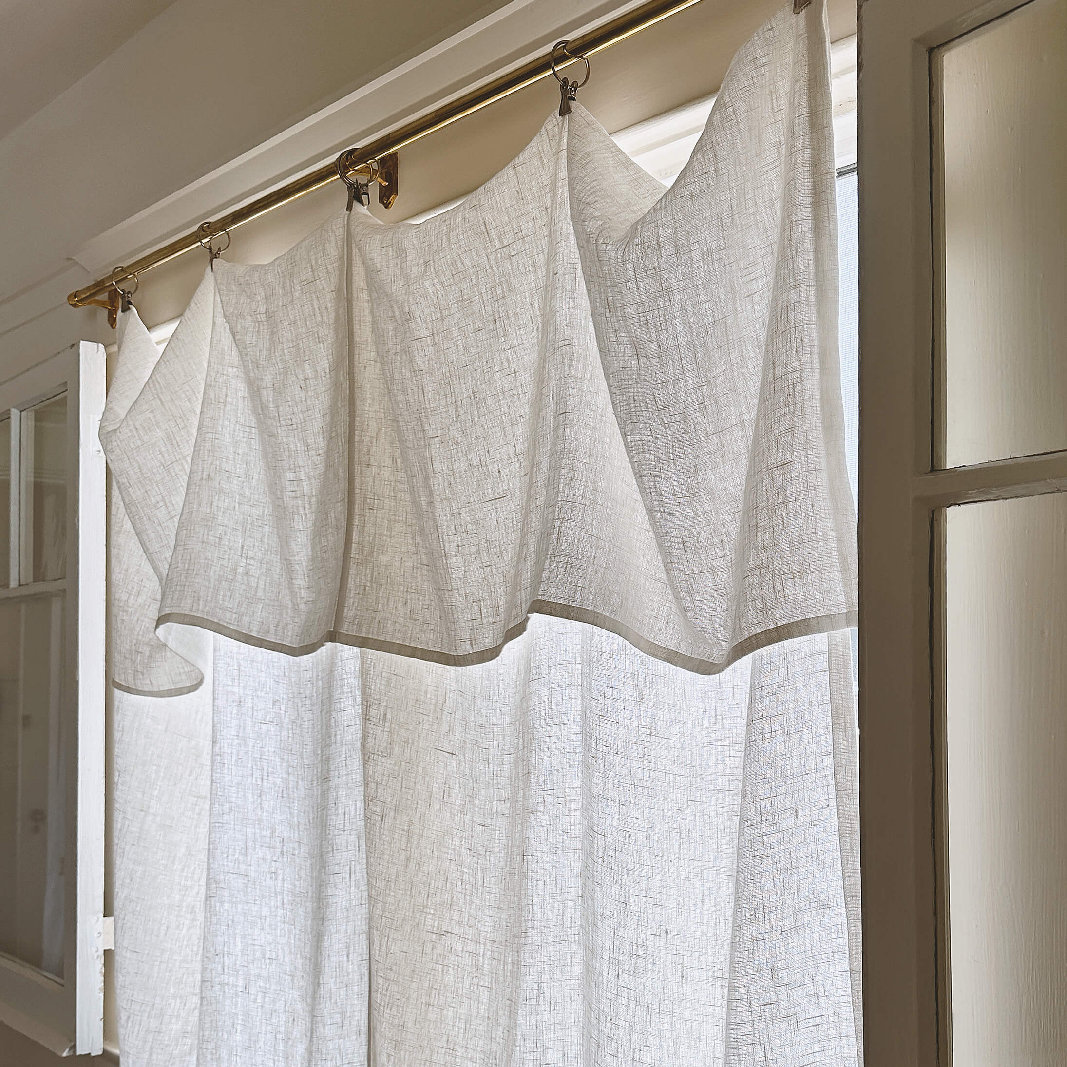 Antique white linen drop cloth curtain panel hung from clip rings in heavyweight 260 g/m² European linen