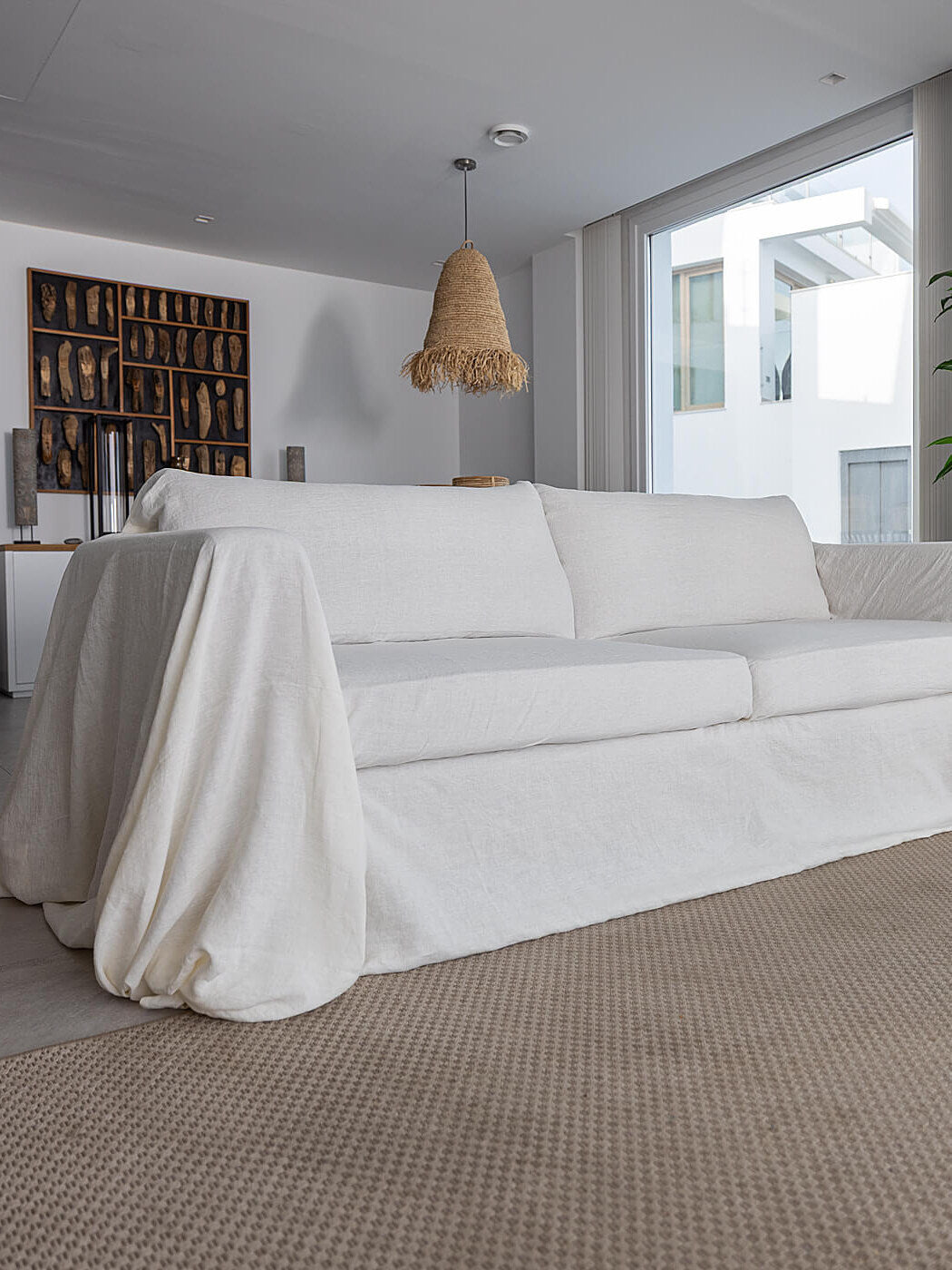 White linen couch cover draped and tucked over a sofa