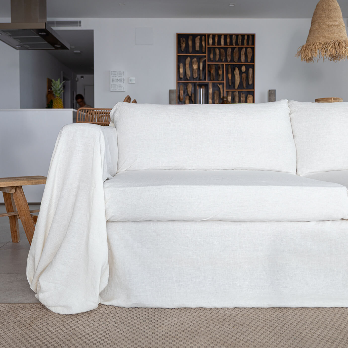 Sofa with a tucked linen couch cover, close-up