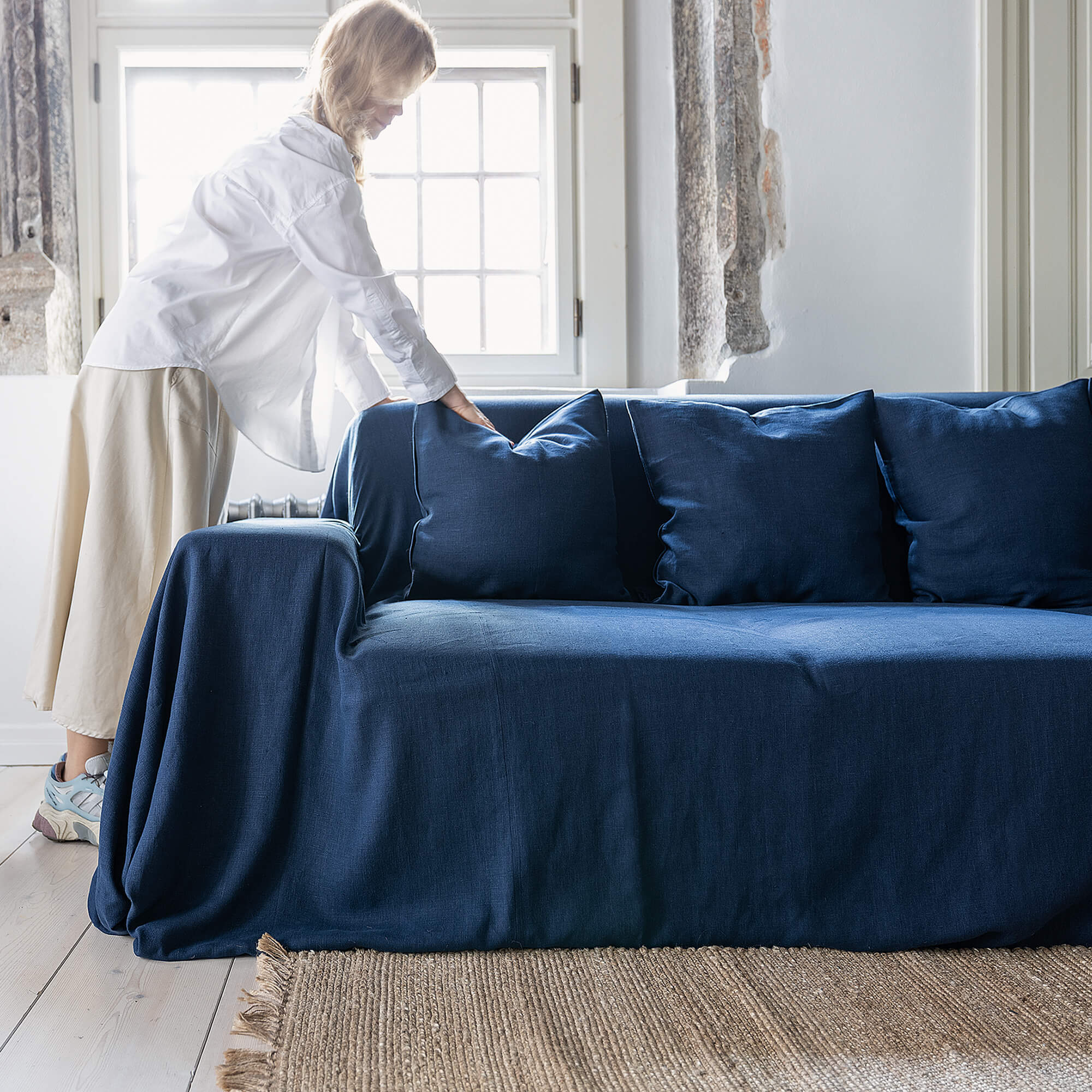 Navy blue linen couch cover designed and crafted to elevate your interior with a fresh look and great energy. It offers a practical solution for safeguarding your furniture against the playful antics of your beloved pets.