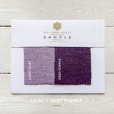 Sample card with fabric swatches labeled 'Light Lilac' and 'Deep Purple' from The Linen Valley on a wooden surface.