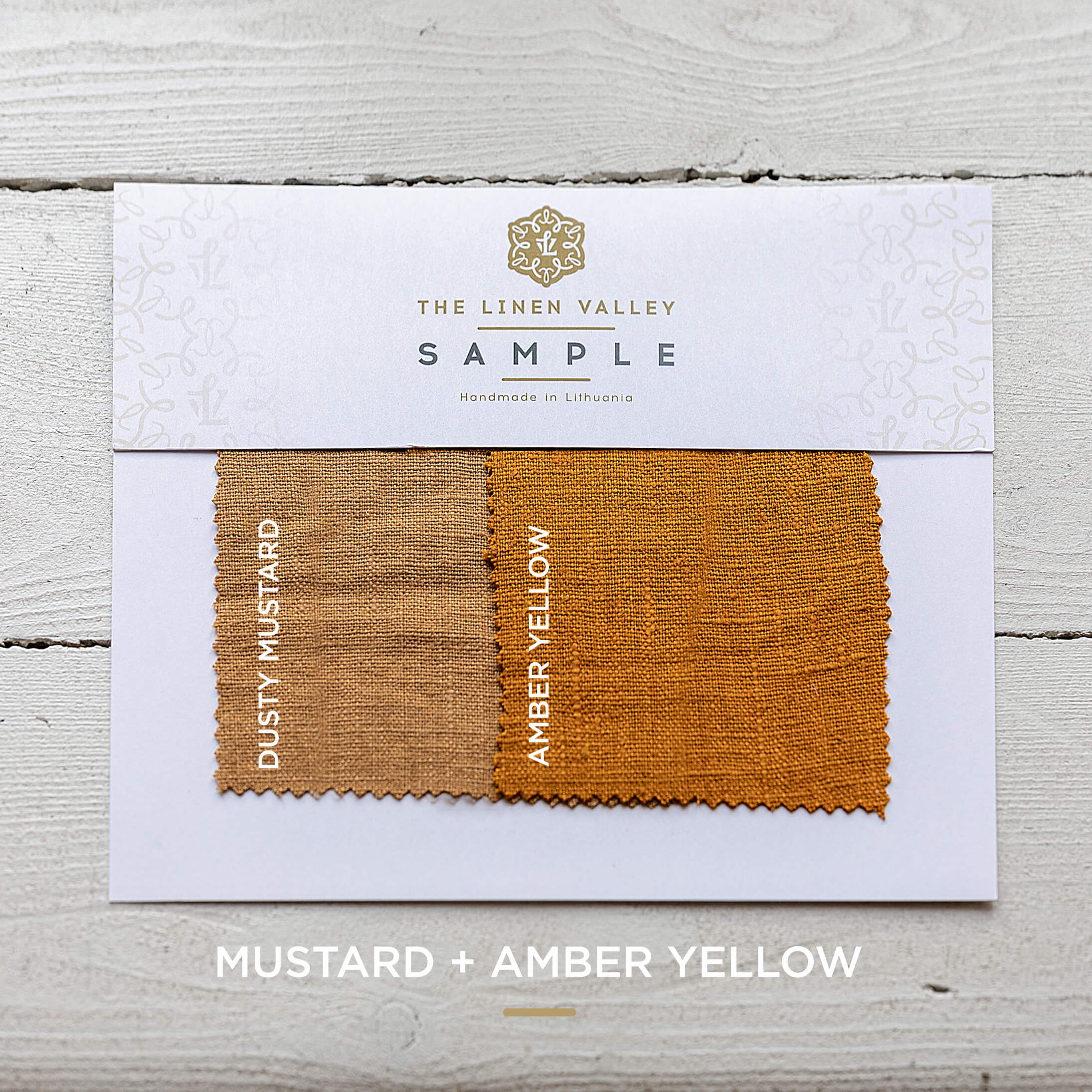 Linen Valley fabric sample card with mustard and amber yellow swatches on a wooden surface.