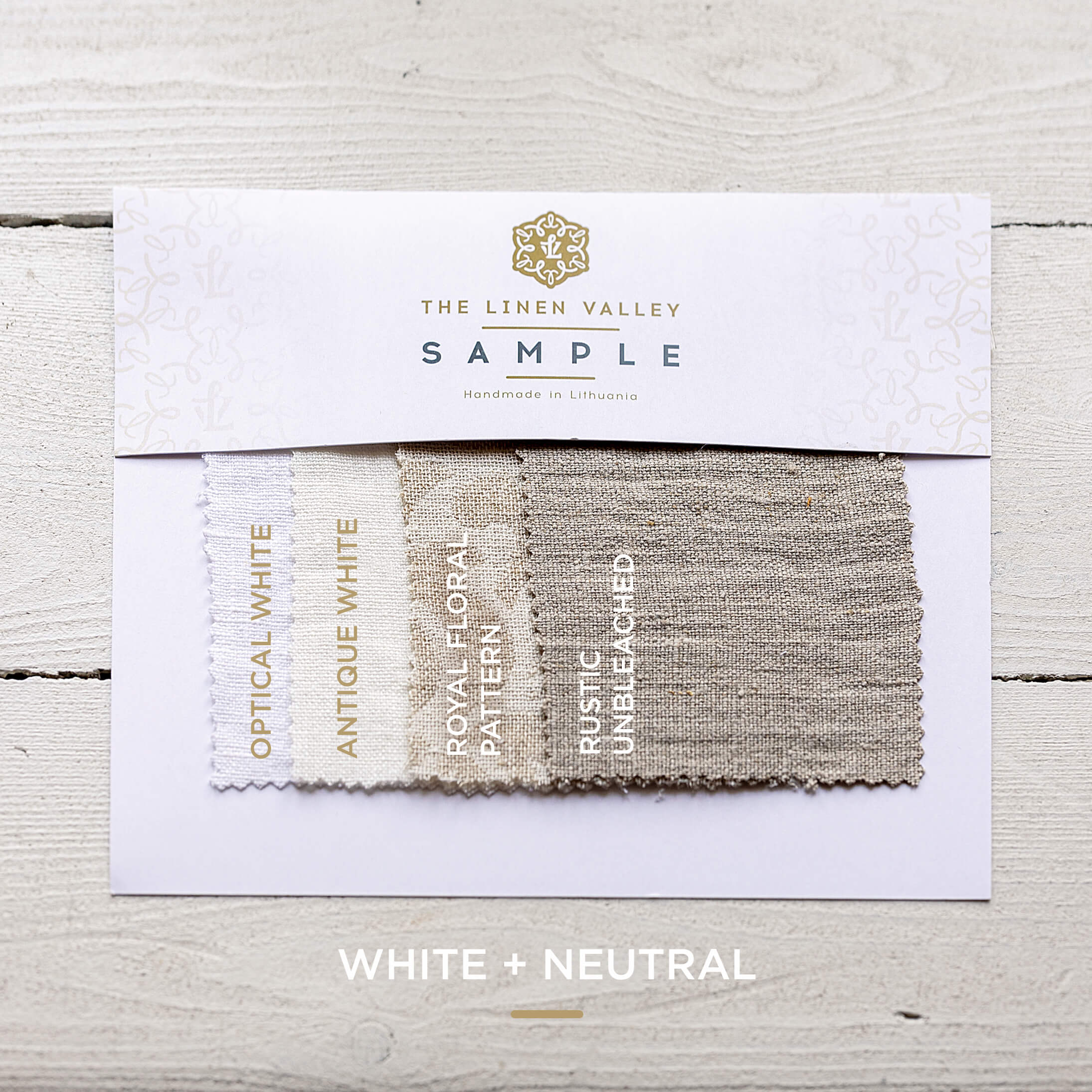 Fabric swatch sample with 'The Linen Valley' branding on a wooden surface