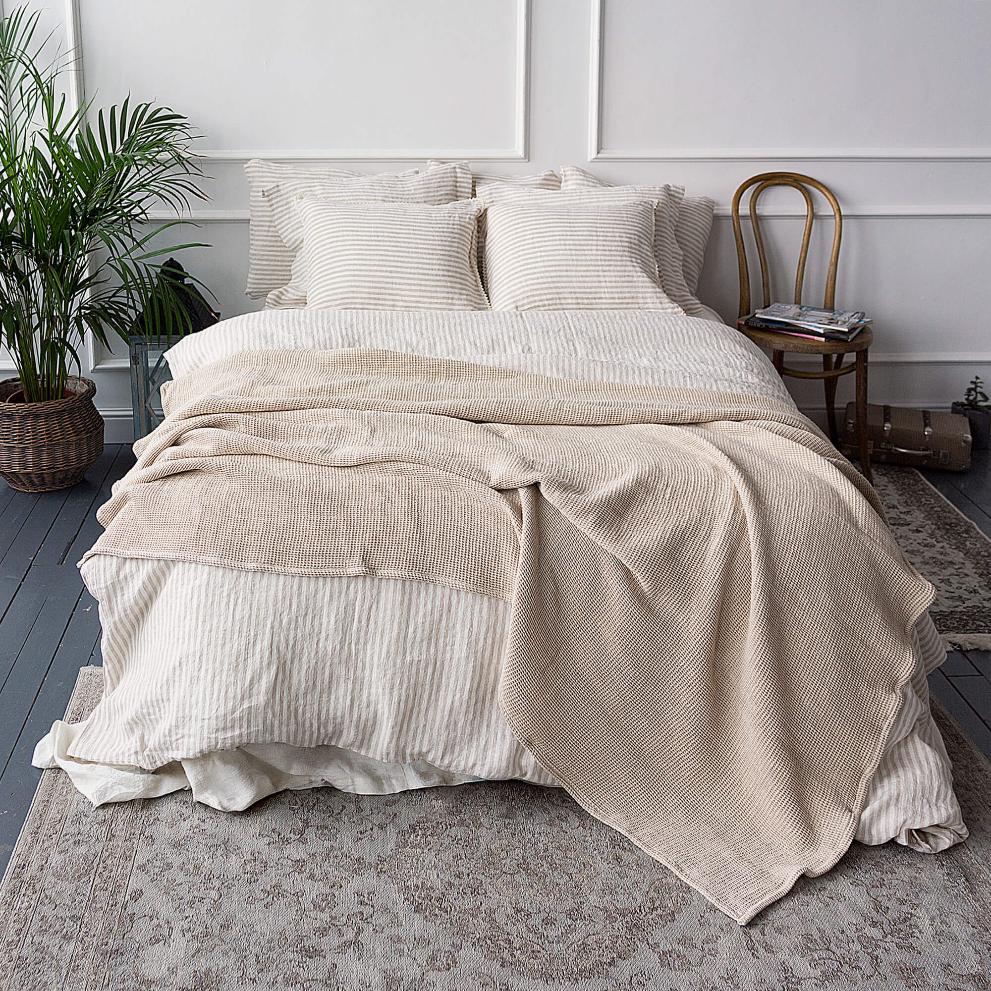 Neatly made bed with beige bedding in a bedroom setting.