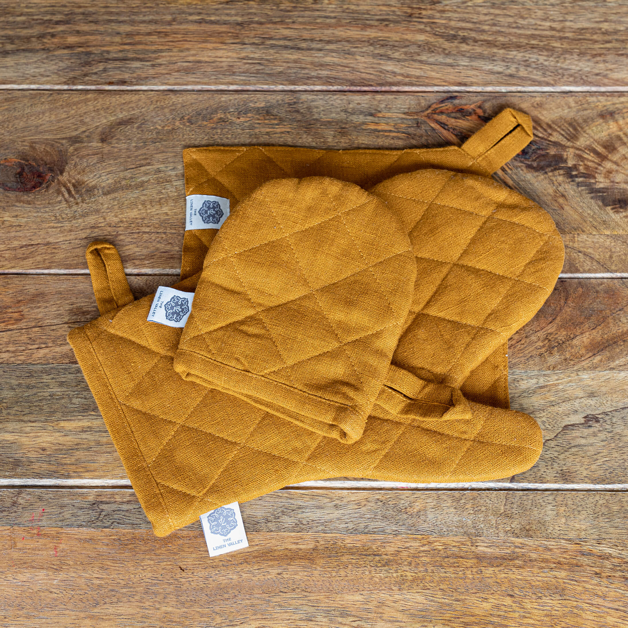 Crafted with care, these amber yellow linen oven mitten sets are the perfect companions for your culinary adventures.