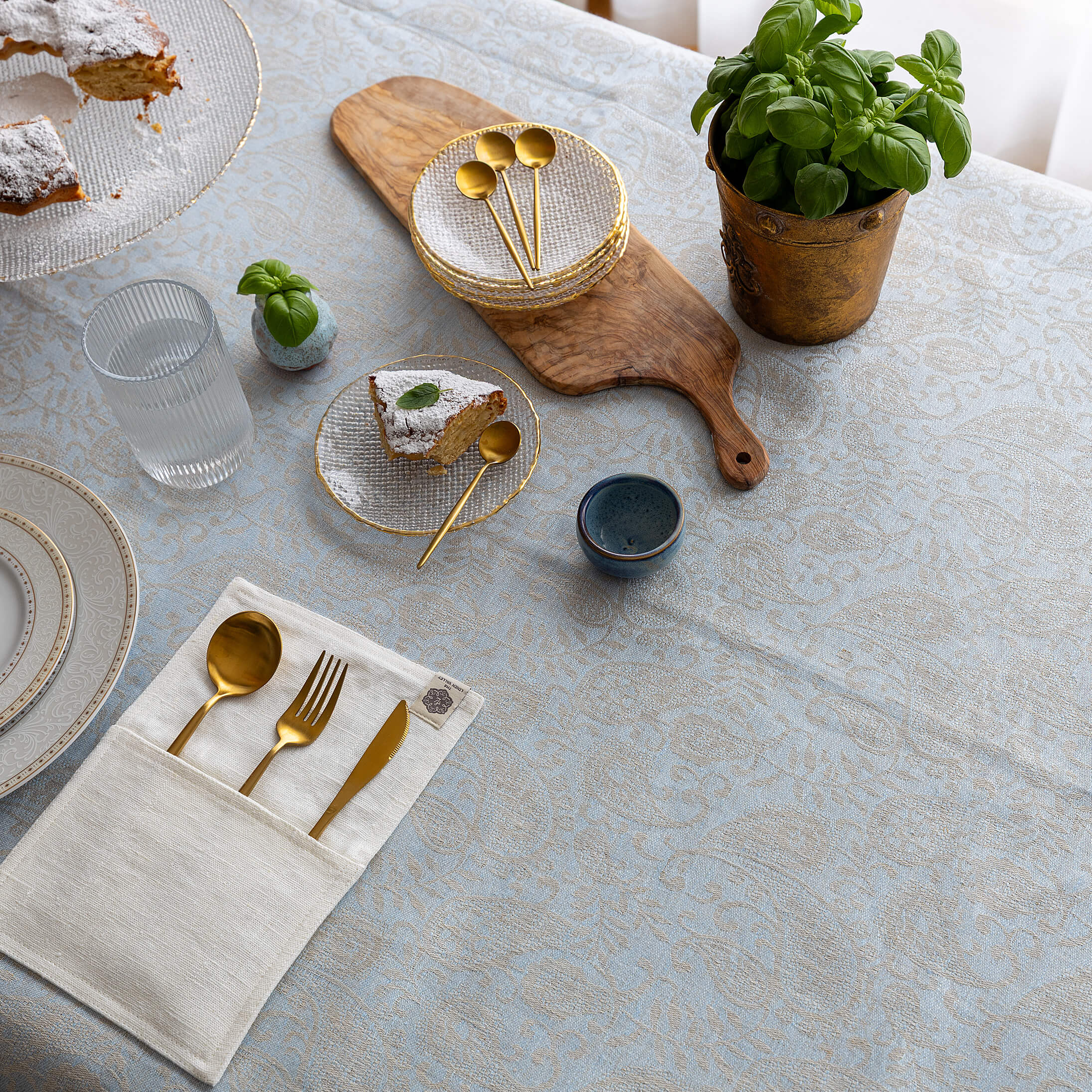 Sky blue floral linen-cotton tablecloth on a dining table, top view
