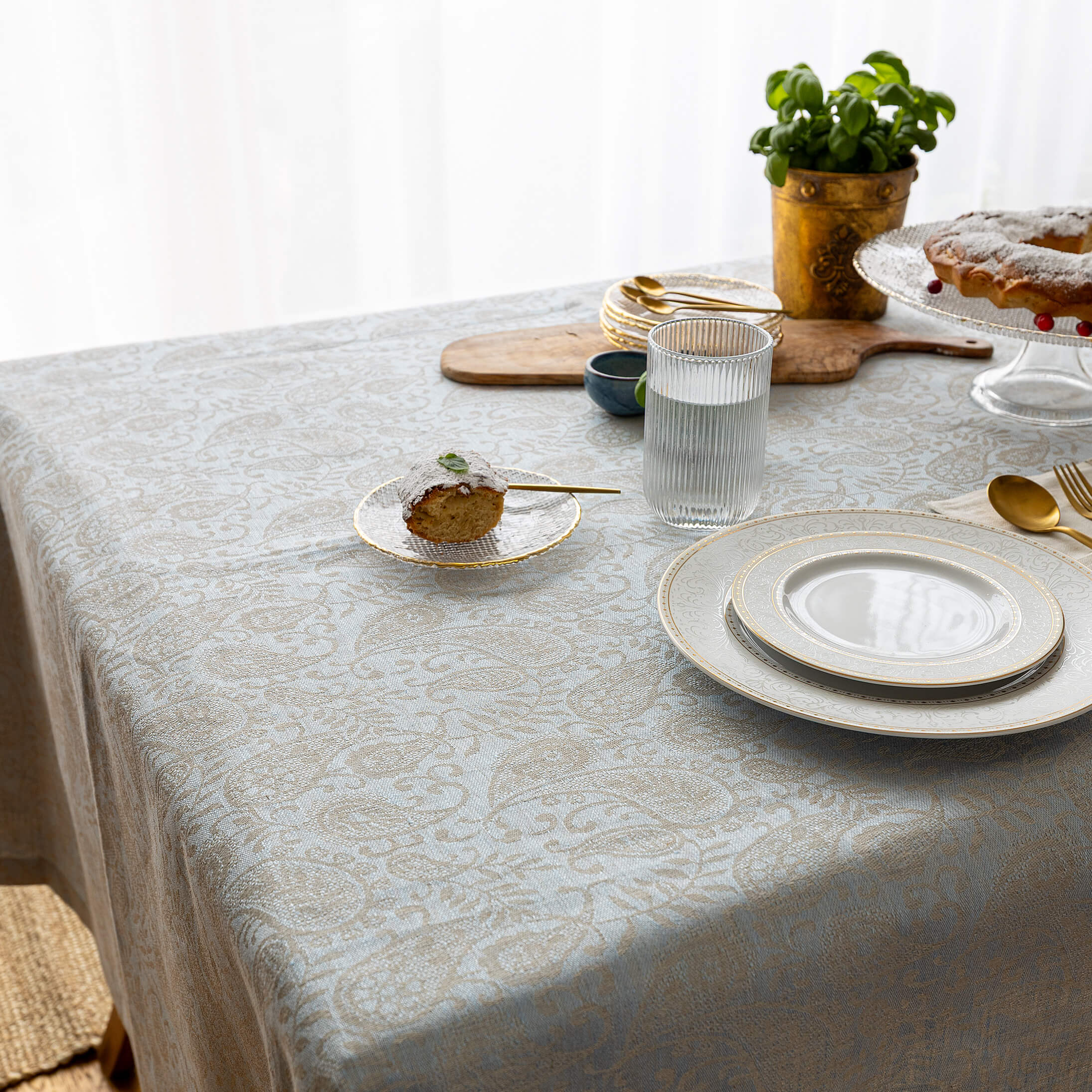 Sky blue paisley jacquard tablecloth draped over a table edge