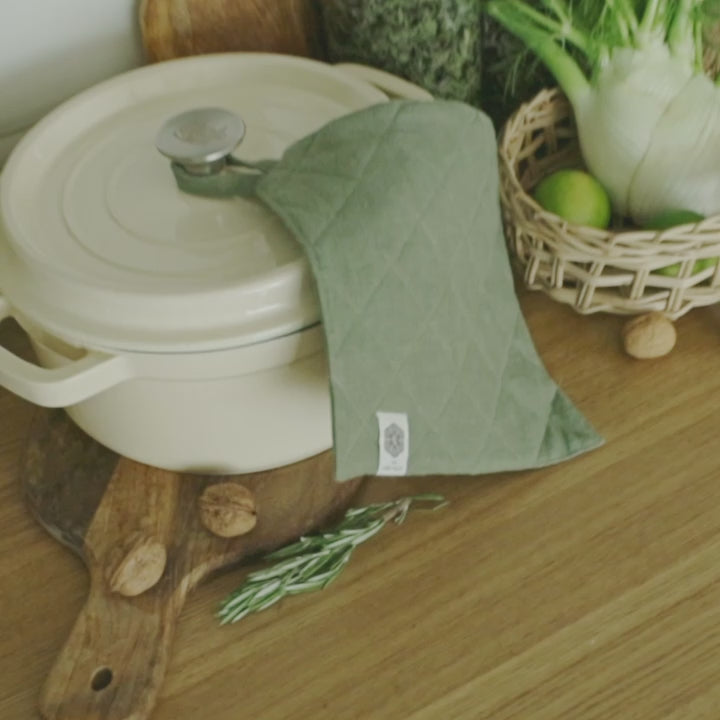 The linen pot holder crafted with a quilted exterior and heat-insulating padding on the inside, it provides reliable protection for your hand and forearm against heat while handling hot dishes and cookware.